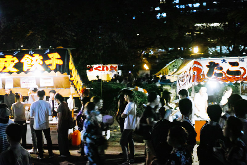 Festival yatai food stalls in Japan selling takoyaki, candied apples, and yakisoba