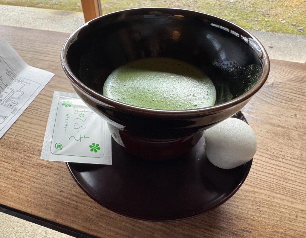 A bowl of matcha green tea served with a traditional wagashi sweet