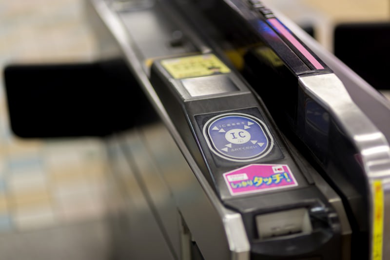 Tapping a Suica IC card at a Japanese train station ticket gate