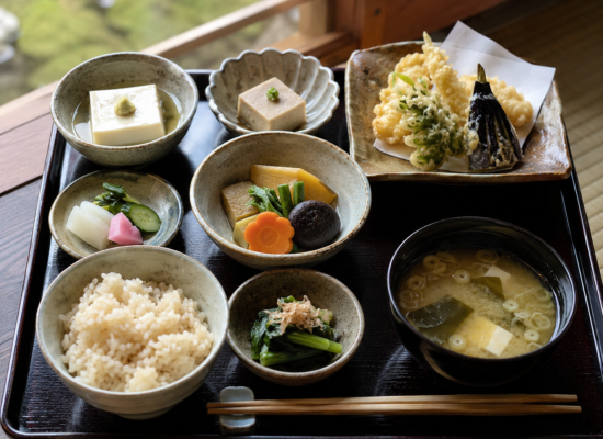 A vegan shojin ryori meal in Japan with tofu, seasonal vegetables, and miso soup on a tray